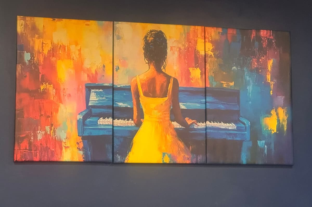 Painting of a woman at the piano on the wall at Black Ivory